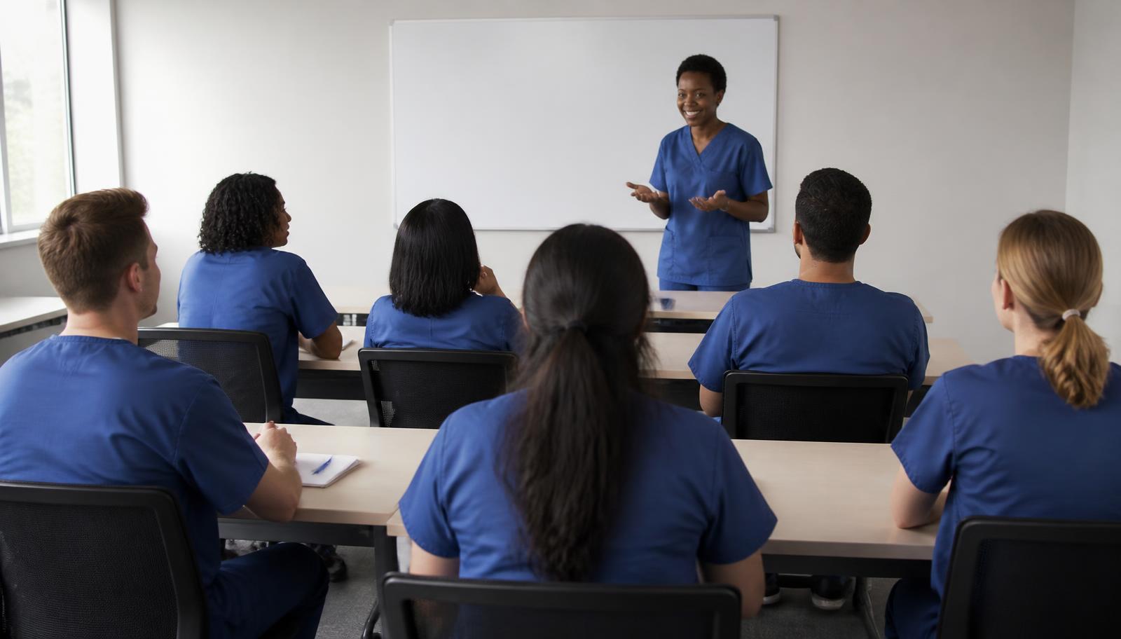 Adult students in scrubs in a small classroom at Nationwide Career Institute
